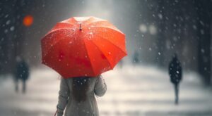 frau geht mit einem regenschirm im regen der straße entlang